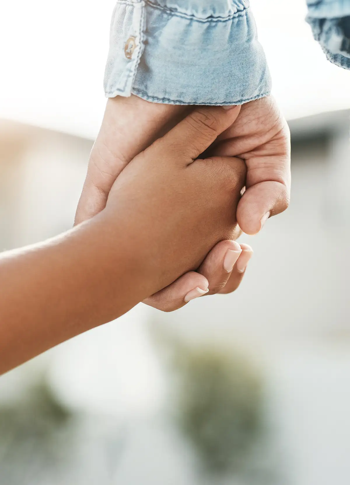 An adult and child holding hands