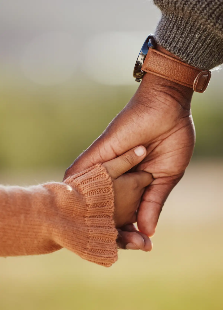 A child holding an adult’s hand